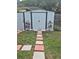 A backyard storage shed is neatly adorned with potted plants and a decorative tiled walkway at 21511 Sw Plantation Sw St, Dunnellon, FL 34431