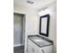 Bathroom featuring a granite countertop, modern faucet and hardware, with a black framed mirror at 226 Locust Ln, Ocala, FL 34472