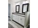 A bathroom featuring a double vanity with granite countertops, framed mirrors, and modern lighting at 226 Locust Ln, Ocala, FL 34472
