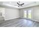 A gray-toned bedroom with wood-look floors, ceiling fan, recessed lighting, and french doors to the backyard at 226 Locust Ln, Ocala, FL 34472