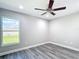 Cozy bedroom with ceiling fan and a large window overlooking the yard at 226 Locust Ln, Ocala, FL 34472