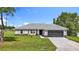 Charming single-story home with a well-manicured lawn and a gray two-car garage door at 226 Locust Ln, Ocala, FL 34472