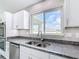 Bright kitchen with stainless steel sink, granite countertops, and white cabinets at 226 Locust Ln, Ocala, FL 34472