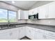 Modern kitchen with white cabinets, stainless steel microwave, and granite countertops at 226 Locust Ln, Ocala, FL 34472