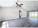 Spacious living room with gray floors, vaulted ceiling, ceiling fan, and sliding glass door at 226 Locust Ln, Ocala, FL 34472