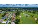 Scenic aerial view of a golf community with lush landscaping, a pond, and mature trees at 2515 Nw 53 Ave, Ocala, FL 34482