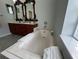 Bathroom with soaking tub features marble surround, fixtures, and towel rack at 2515 Nw 53 Ave, Ocala, FL 34482