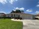 Home exterior displaying a well-manicured front lawn, tidy landscaping, and a classic neutral color palette at 2515 Nw 53 Ave, Ocala, FL 34482