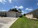 Exterior shot featuring the garage and an adjacent view of the house with green grass and landscaping at 2515 Nw 53 Ave, Ocala, FL 34482