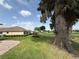 The backyard features a lush lawn, mature trees, and landscaping at 2515 Nw 53 Ave, Ocala, FL 34482