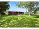 Spacious backyard features lush lawn, mature tree, and screened porch at 32 Dogwood Drive Loop, Ocala, FL 34472