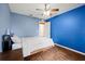 Bedroom with hard wood flooring and light blue painted walls, with a ceiling fan at 32 Dogwood Drive Loop, Ocala, FL 34472