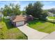 Aerial view of a single-story home boasting solar panels, attached garage, and a spacious driveway at 32 Dogwood Drive Loop, Ocala, FL 34472