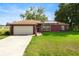 Charming single-story home with a well-manicured lawn, attached garage, and inviting front entrance at 32 Dogwood Drive Loop, Ocala, FL 34472
