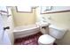 Retro bathroom features a tub, window, toilet, and sink with vintage-style tiling at 3418 Se 94Th St, Ocala, FL 34480