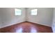 A bright, serene bedroom features two windows and sleek wood-look floors for a modern and inviting space at 3418 Se 94Th St, Ocala, FL 34480