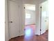 Hallway with wood-look floors, neutral walls, and interior doors offering a glimpse into the adjacent rooms at 3418 Se 94Th St, Ocala, FL 34480