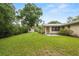 Large backyard with green grass, mature trees, and home featuring a metal roof at 3621 Se 12Th Pl, Ocala, FL 34471