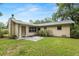 View of a cozy backyard with a well-maintained lawn and a neutral-toned home exterior at 3621 Se 12Th Pl, Ocala, FL 34471