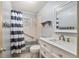 This renovated bathroom has a tub with a shower and a modern vanity at 3621 Se 12Th Pl, Ocala, FL 34471