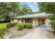View of a single-story home with a covered carport, front garden area, and small walkway at 3621 Se 12Th Pl, Ocala, FL 34471
