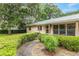 A charming single-story home with a metal roof, walkway to front door, and manicured landscaping at 3621 Se 12Th Pl, Ocala, FL 34471