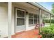 Close up view of front porch with seating, a screen door and front windows at 3621 Se 12Th Pl, Ocala, FL 34471