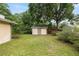View of shed in backyard with surrounding grass and mature trees at 3621 Se 12Th Pl, Ocala, FL 34471