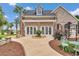 Backyard patio area of brick home with lush landscaping, outdoor seating, and pergola at 4550 County Road 104, Oxford, FL 34484