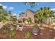 Exterior of brick home showcasing landscaped backyard, foliage, and charming features at 4550 County Road 104, Oxford, FL 34484