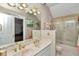 Bathroom with double sinks, marble countertops, and glass-enclosed shower and bath at 4550 County Road 104, Oxford, FL 34484