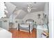 Charming bedroom with sloped ceilings, decorative chandelier and plenty of natural light from a window at 4550 County Road 104, Oxford, FL 34484