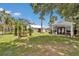 Exterior view of property with lush landscaping, charming cabin, and fountain feature at 4550 County Road 104, Oxford, FL 34484