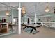 Spacious game room with pool table, foosball table, and elegant chandeliers at 4550 County Road 104, Oxford, FL 34484