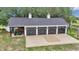 Spacious garage with multiple bays, ample parking, and an adjacent covered area for equipment storage at 4550 County Road 104, Oxford, FL 34484