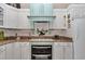 Charming kitchen featuring custom white cabinets, granite countertops, and modern appliances at 4550 County Road 104, Oxford, FL 34484