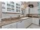 Close-up of the kitchen highlighting white cabinets, granite countertops, and modern dishwasher at 4550 County Road 104, Oxford, FL 34484