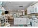 Open-concept kitchen with white cabinets, modern appliances, and adjacent living area at 4550 County Road 104, Oxford, FL 34484