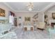 Bright living room featuring a crystal chandelier, plush seating, and decorative accents at 4550 County Road 104, Oxford, FL 34484