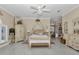 Large main bedroom with ornate furnishings, decorative ceiling fan, and an ensuite bathroom at 4550 County Road 104, Oxford, FL 34484