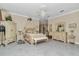 Bright bedroom with a chandelier, neutral decor, and seating area at 4550 County Road 104, Oxford, FL 34484
