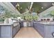 Outdoor kitchen featuring stainless steel appliances, ample counter space, and stylish cabinetry at 4550 County Road 104, Oxford, FL 34484