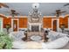 Inviting outdoor living room with comfortable seating, stone fireplace and charming chandeliers at 4550 County Road 104, Oxford, FL 34484