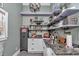 A well-stocked pantry features granite countertops, floating shelves, and a metal cabinet at 4550 County Road 104, Oxford, FL 34484