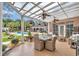 Inviting covered patio with elegant seating and dining area overlooking a lush backyard and pool at 4550 County Road 104, Oxford, FL 34484