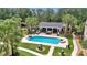 Aerial view of a luxurious pool and cabana surrounded by lush landscaping at 4550 County Road 104, Oxford, FL 34484