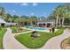 Lush backyard with a stunning pool, manicured lawns, and stone walkways at 4550 County Road 104, Oxford, FL 34484