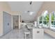 A modern wet bar featuring marble countertops, stylish stools, and arched windows providing natural light at 4550 County Road 104, Oxford, FL 34484
