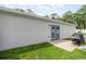 Modern structure with a patio, blue double doors, neutral siding, and a well-maintained lawn at 5063 Se 168Th Ter, Ocklawaha, FL 32179