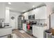 Well-lit kitchen with stainless steel appliances, white cabinets, and a granite countertop at 5063 Se 168Th Ter, Ocklawaha, FL 32179